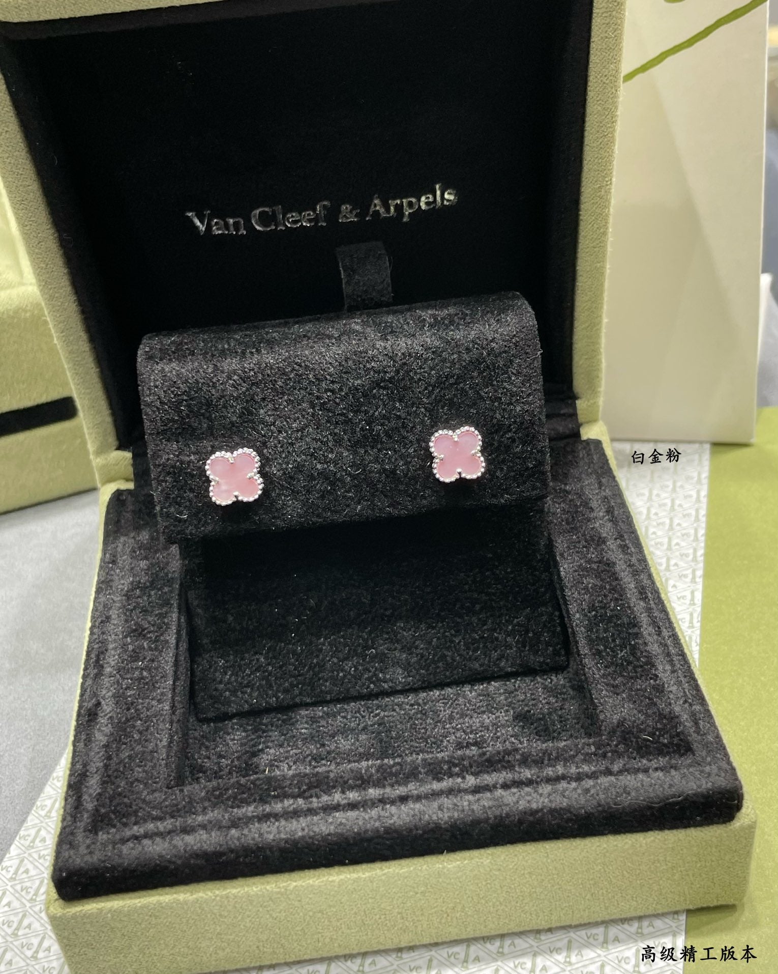 Four-leaf clover stud earrings with pink enamel in a black velvet-lined box