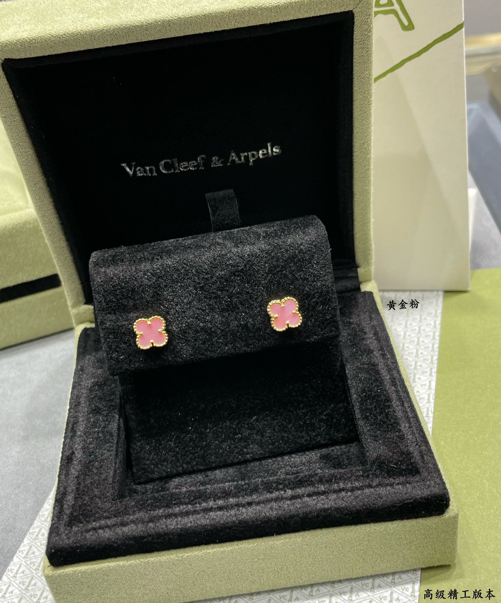 Four-leaf clover stud earrings with pink enamel displayed in black gift box