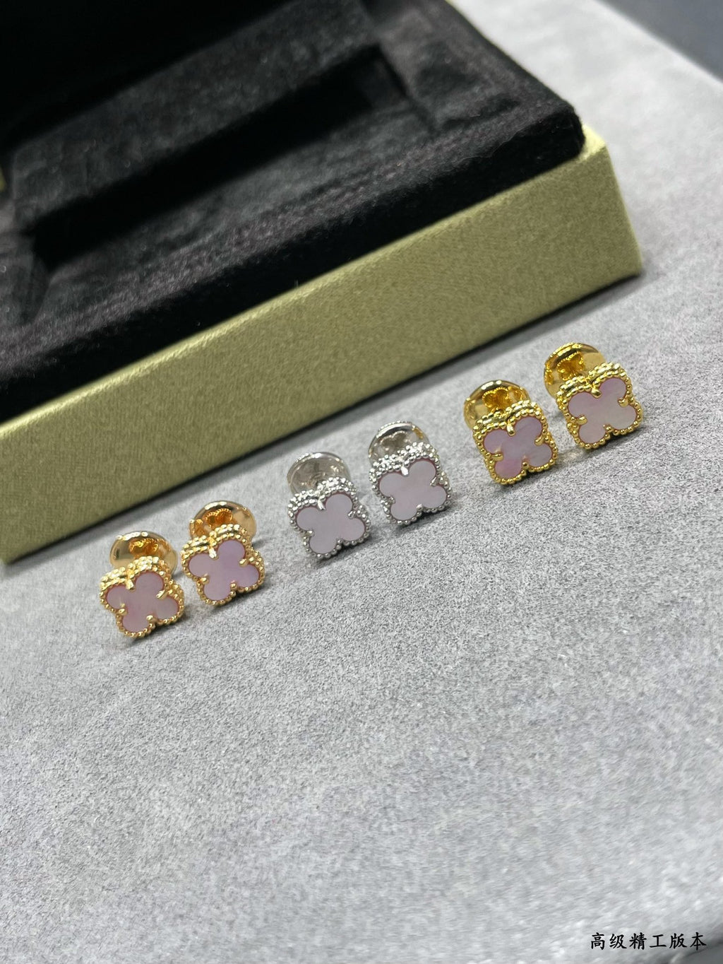 Four-leaf clover stud earrings set with gold, silver, and pink enamel details