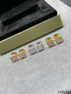 Four-leaf clover stud earrings set with gold, silver, and pink enamel details