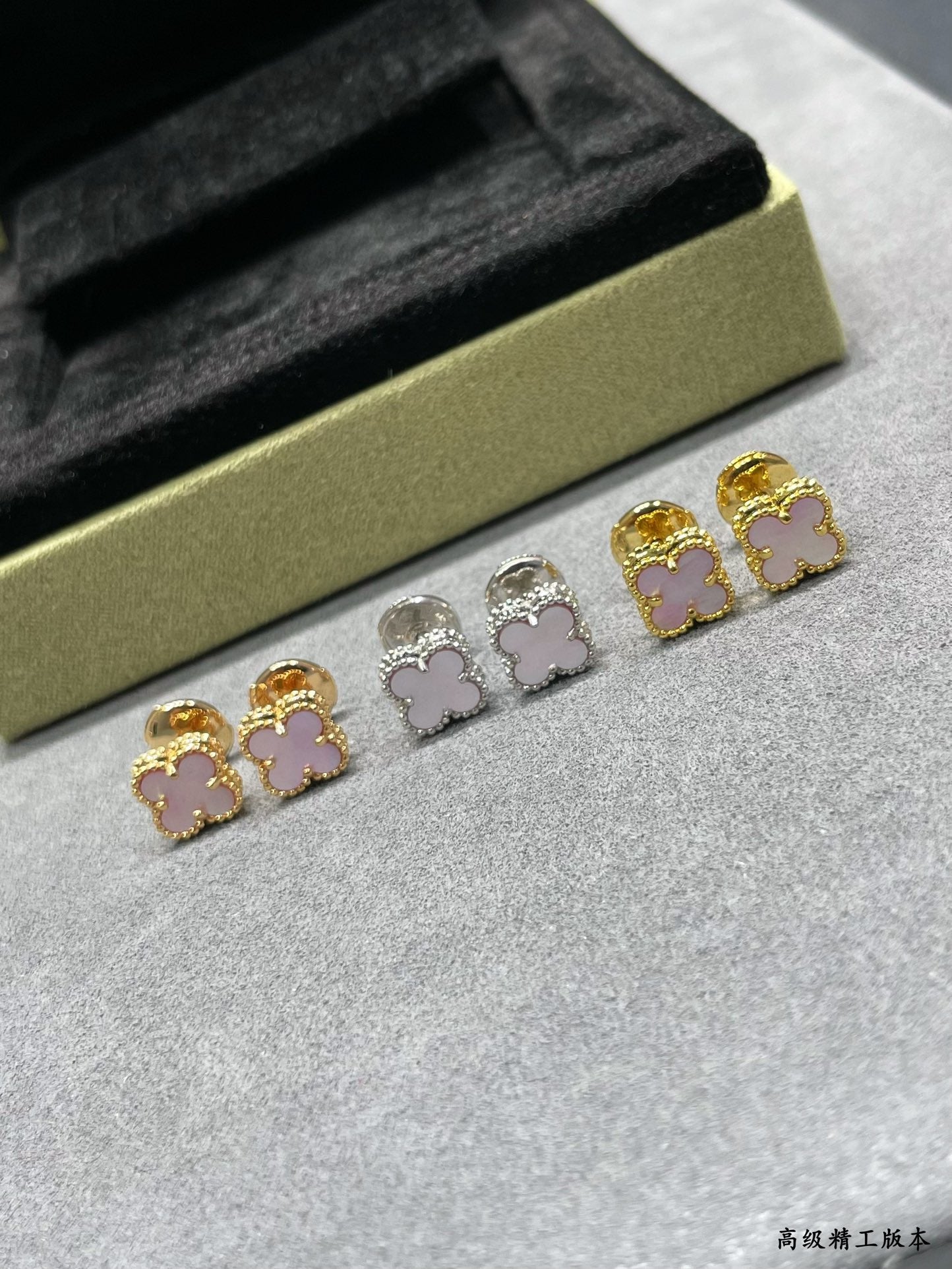 Four-leaf clover stud earrings set with gold, silver, and pink enamel details