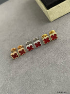Clover stud earrings with gold and silver frames and red enamel flower centers