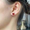 Red enamel clover stud earring on ear with small post backing