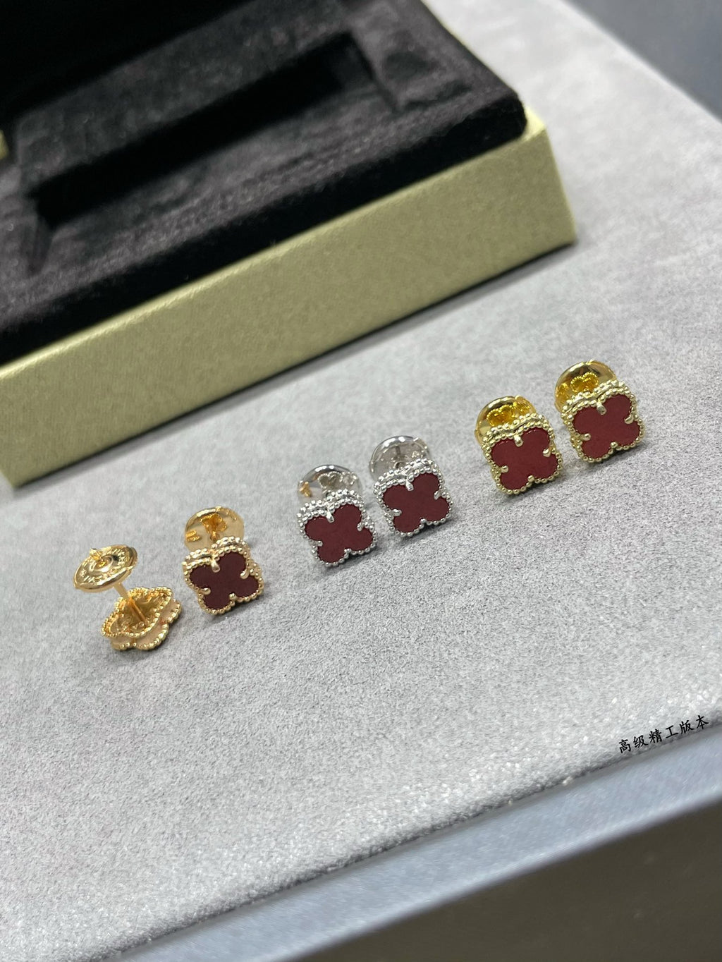 Clover motif stud earrings set, with gold, silver, and red enamel accents