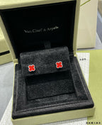 Pair of red enamel clover stud earrings in an open presentation box