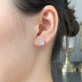 Clover motif stud earring in silver-tone, worn on ear