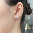 Clover motif stud earring in silver-tone, worn on ear