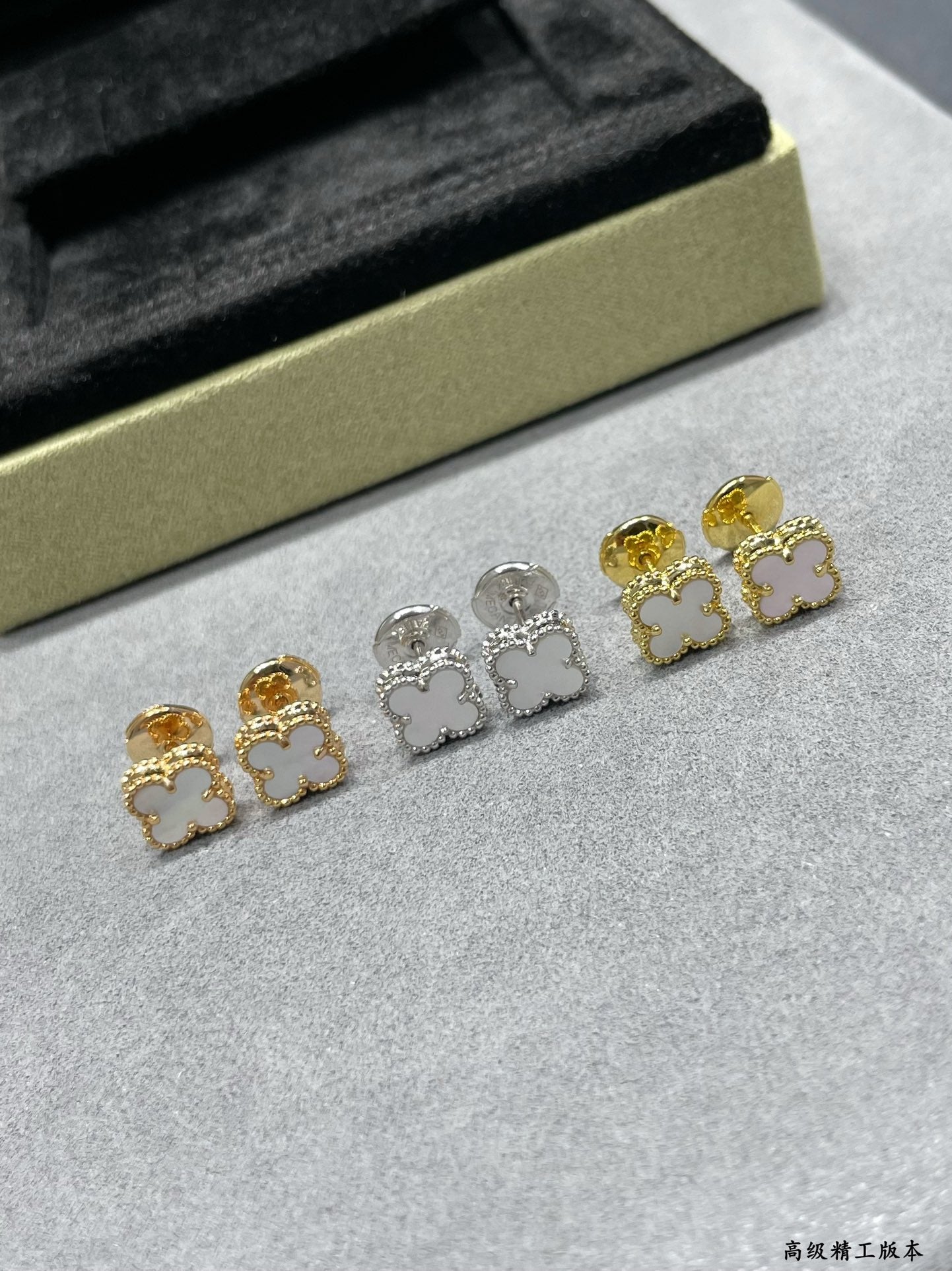 Clover stud earrings set in gold-tone and silver-tone, five pieces on display