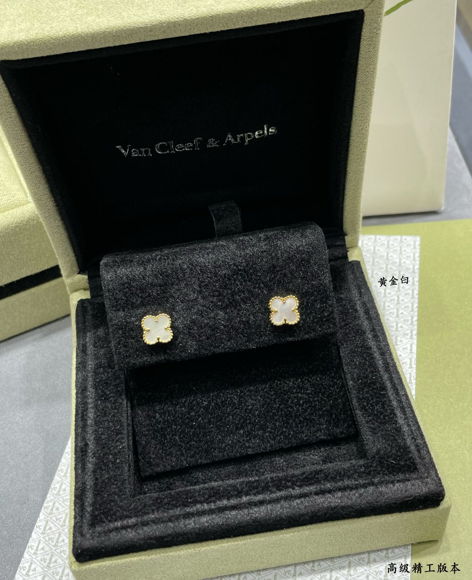 Gold-tone clover stud earrings in black velvet presentation box