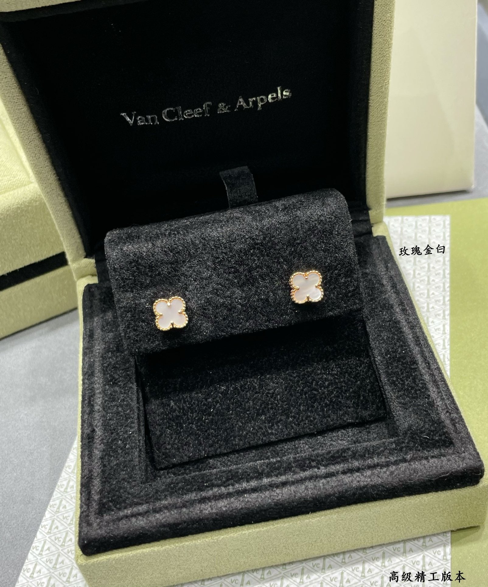 Gold-tone clover stud earrings in black velvet presentation box