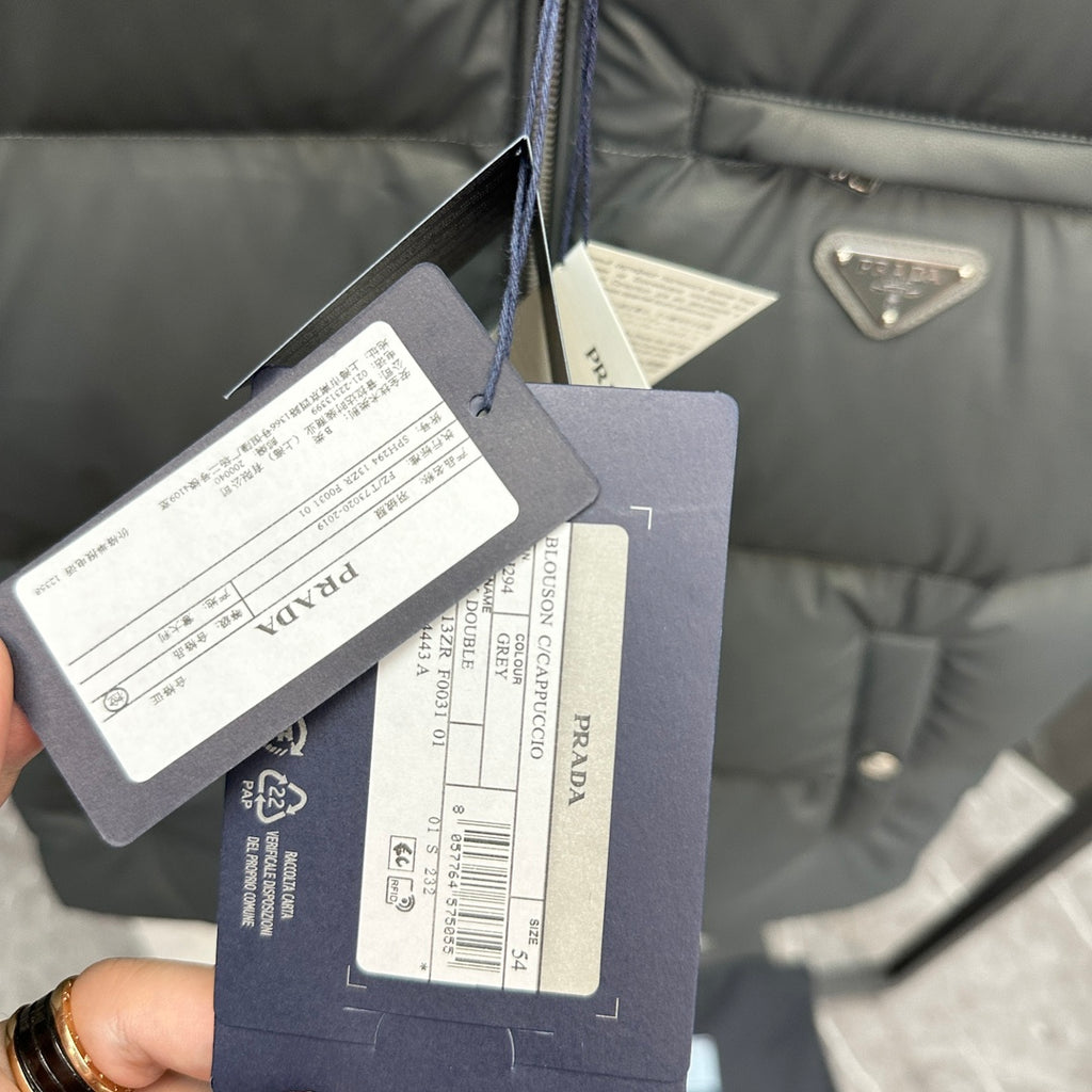 Prada puffer vest clothing tags and size labels attached near the zipper