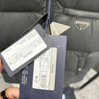Prada puffer vest clothing tags and size labels attached near the zipper
