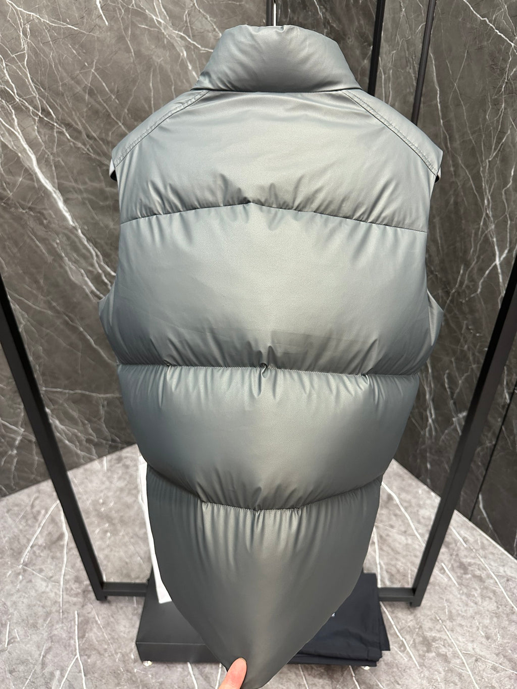 Light gray quilted puffer vest back view with hooded collar and full-length zipper
