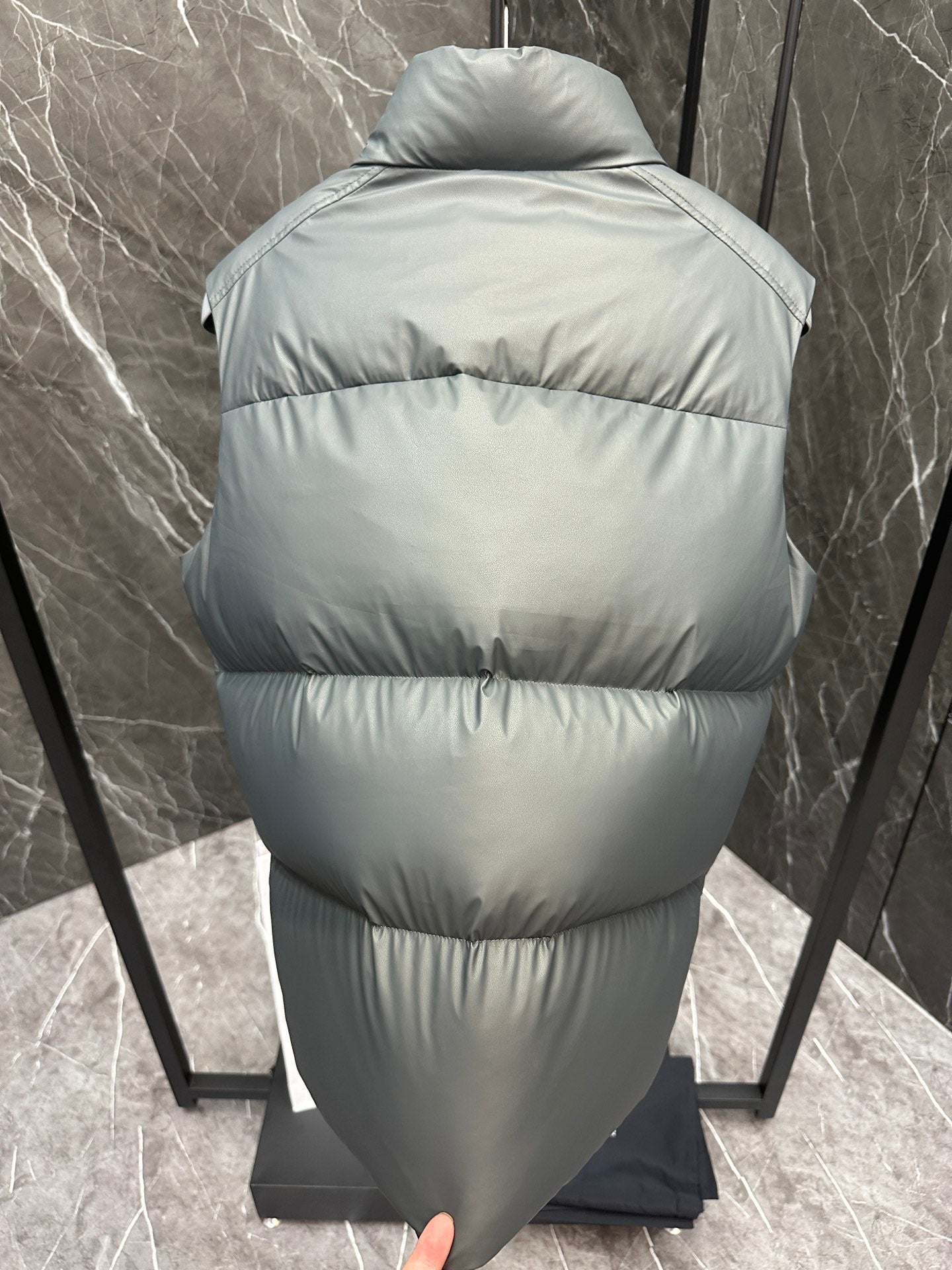 Light gray quilted puffer vest back view with hooded collar and full-length zipper