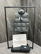 Light gray sleeveless puffer vest with high neck, front zipper, and Prada logo patch