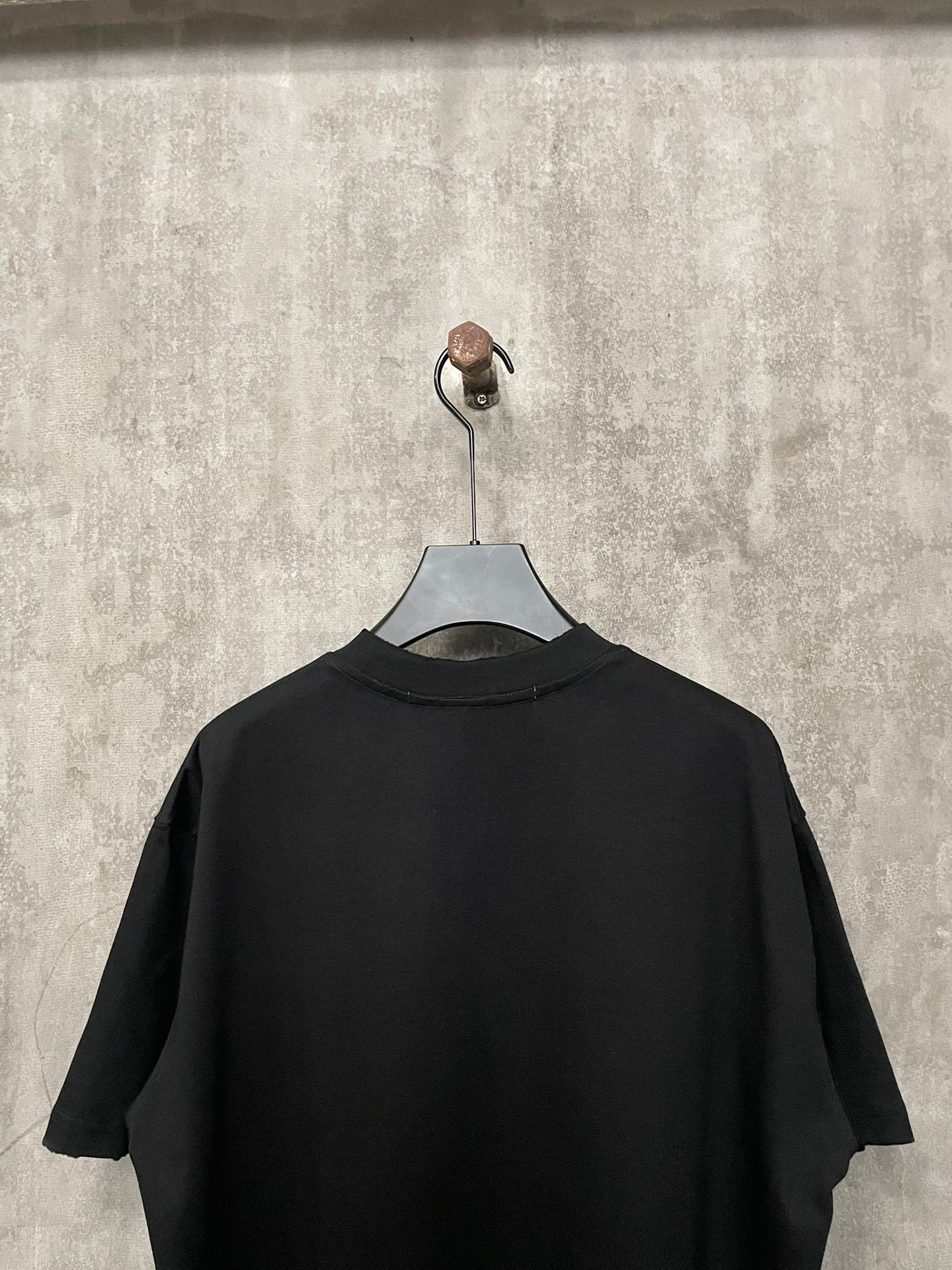 Black short-sleeve T-shirt back view on hanger