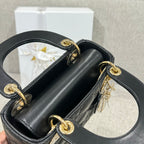 Black Dior quilted handbag open top with gold-tone ring handles and chain strap