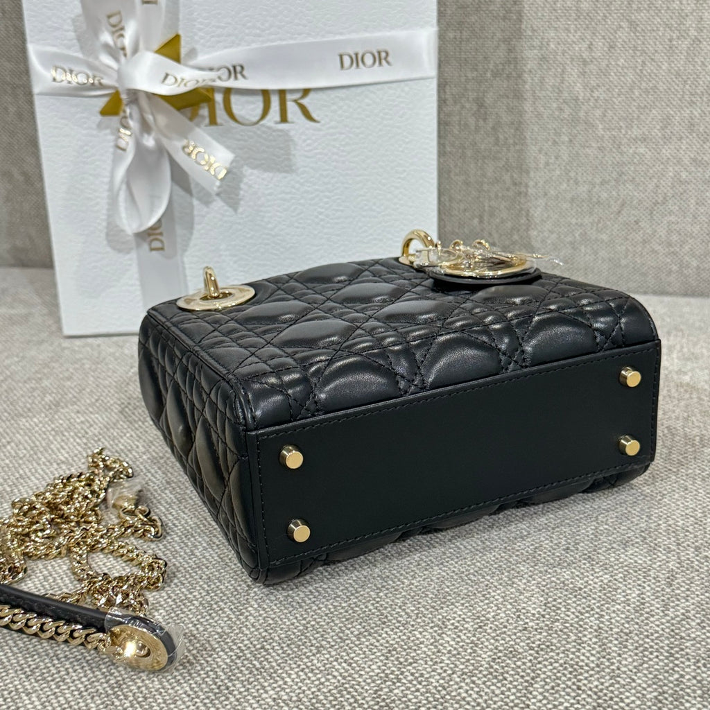 Black Dior quilted handbag with top handle, front studs, and gold-tone hardware
