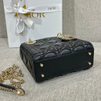 Black Dior quilted handbag with top handle, front studs, and gold-tone hardware