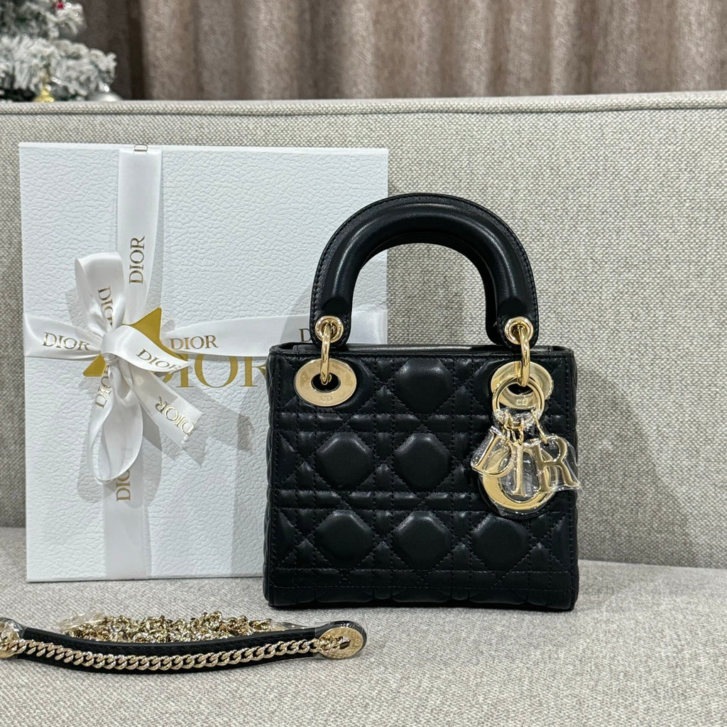 Black Dior quilted top-handle handbag with gold hardware and dangling charm