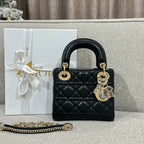 Black Dior quilted top-handle handbag with gold hardware and dangling charm