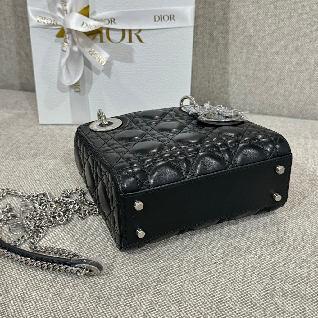 Black quilted leather Dior handbag with shoulder chain and silver studs, side view.
