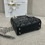 Black quilted leather Dior handbag with shoulder chain and silver studs, side view.