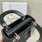 Black quilted leather Dior mini handbag open top with silver rings and chain strap.