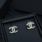 Chanel accessory: pearl and crystal CC stud earrings in a dark jewelry tray