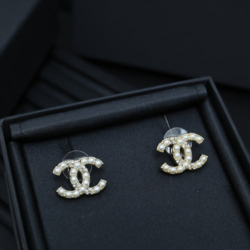 Chanel accessory: pearl and crystal CC stud earrings in a dark jewelry tray