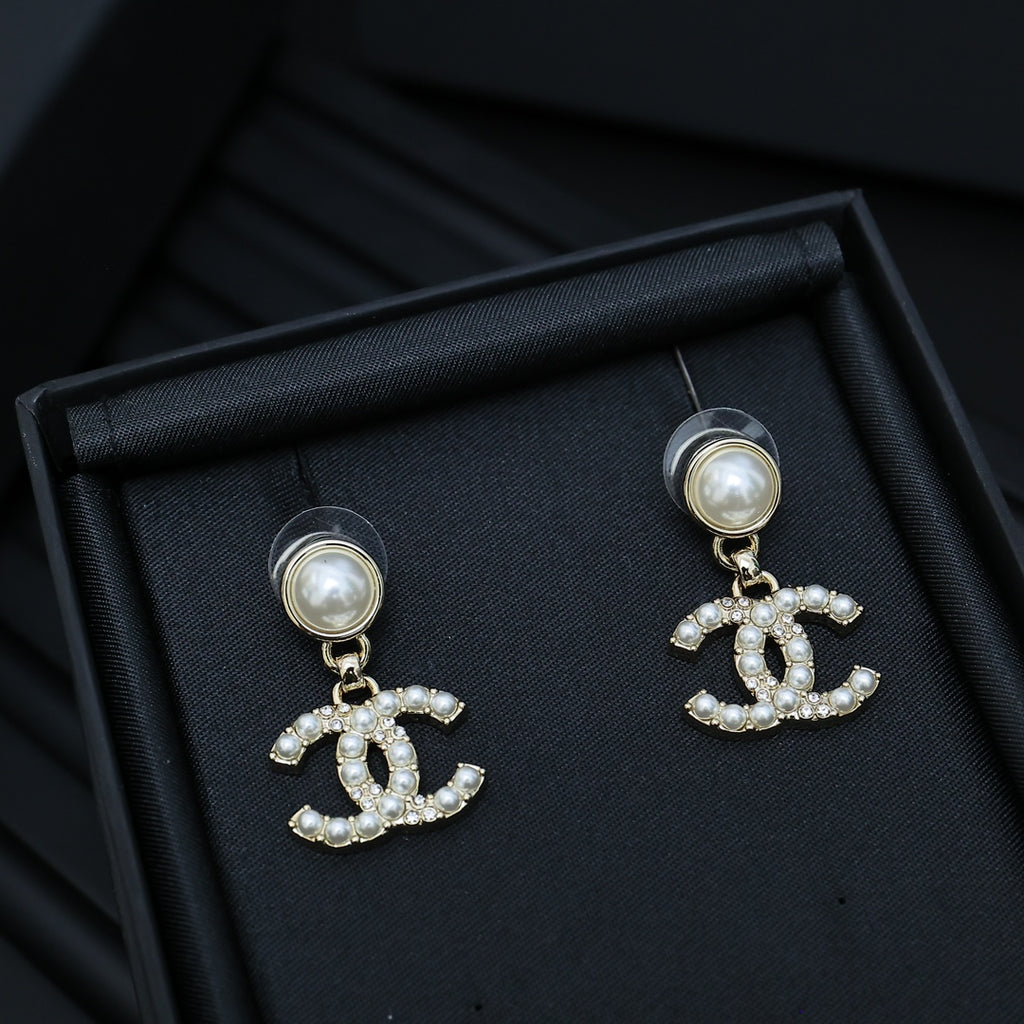 Chanel accessory: round pearl stud earrings with dangling CC crystal charm