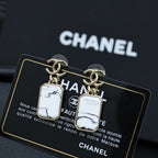 Gold-tone drop earrings with white marbled rectangular pendants on a card