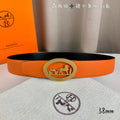 Hermes belt, orange leather with oval metal logo buckle and engraved motifs