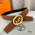 Hermes belt in tan leather with gold-tone oval buckle and long strap end.