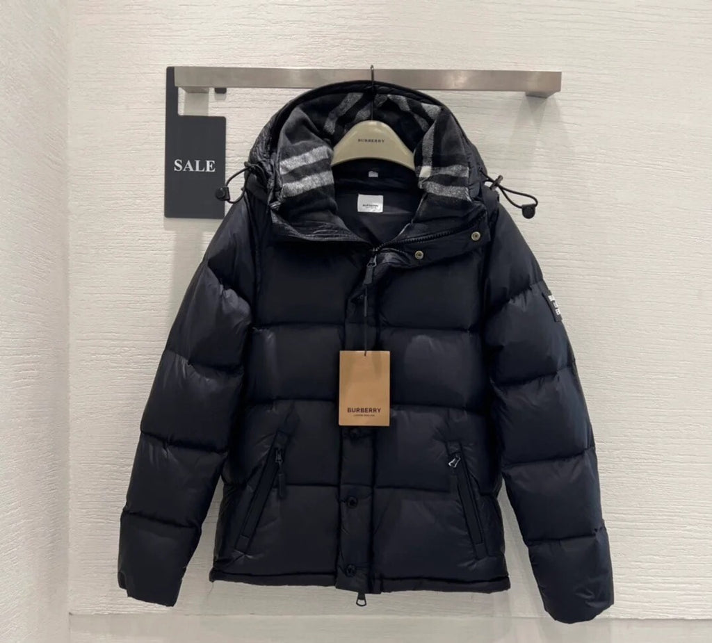 Burberry puffer jacket with dark insulated shell, plaid hood, drawstring waist and zipper