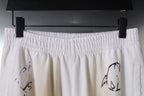 White elastic waistband pants with black graphic motif at front