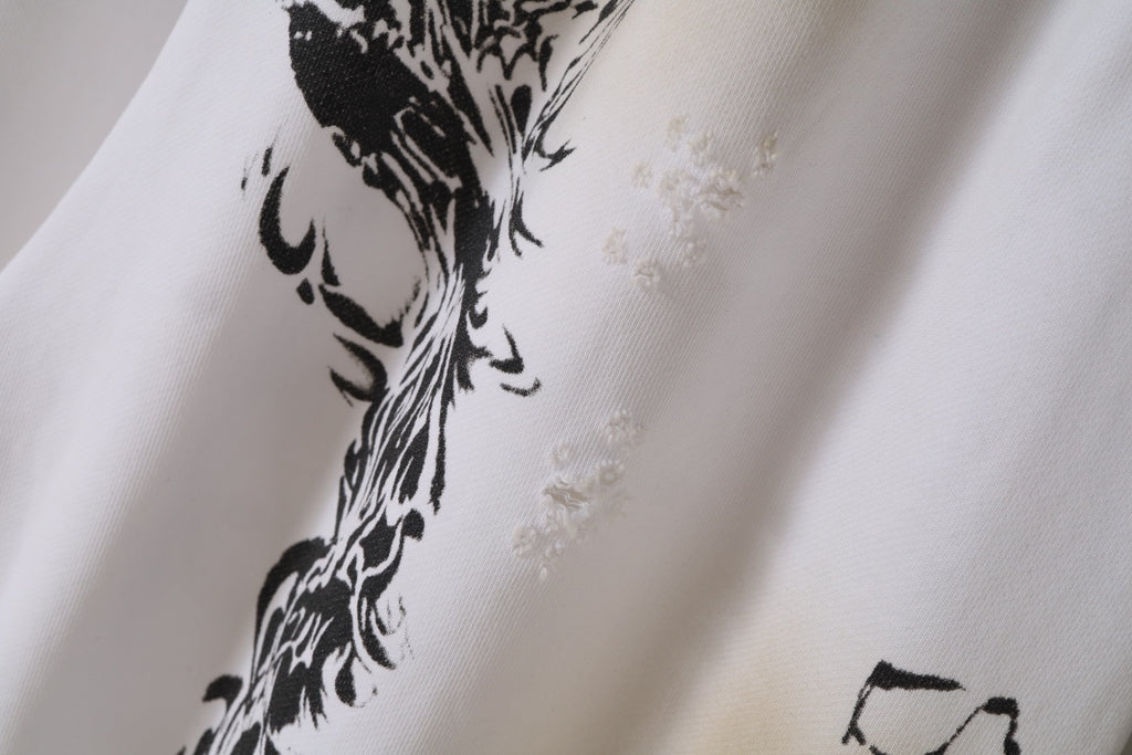 White fabric close-up with black ornate graphic print