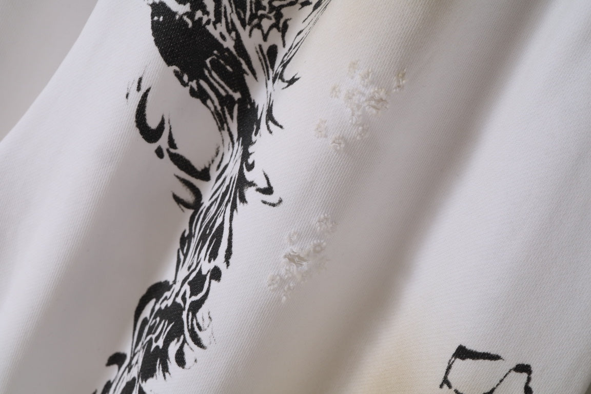 White fabric close-up with black ornate graphic print