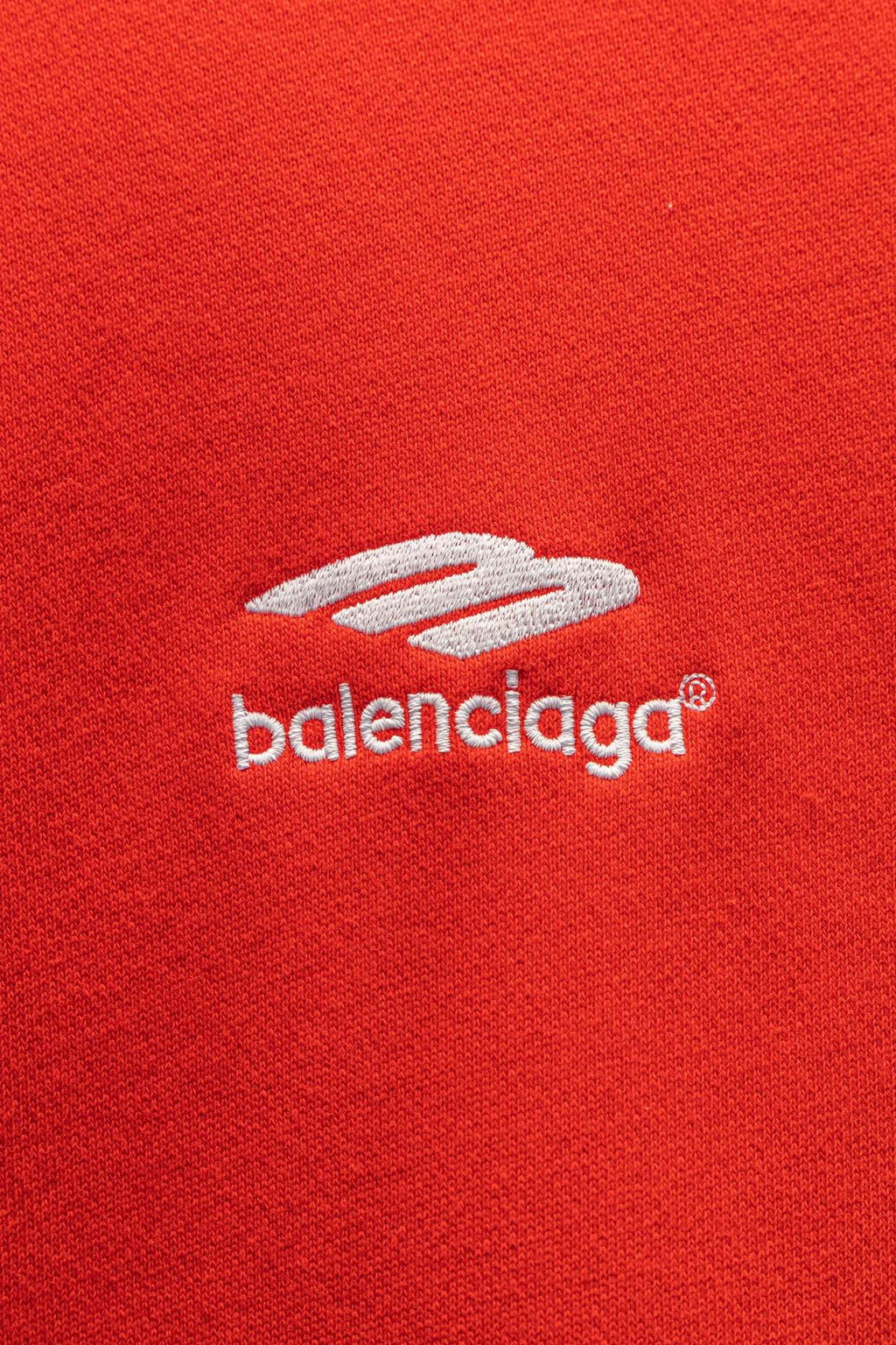 Red hoodie chest logo and zipper pull detail