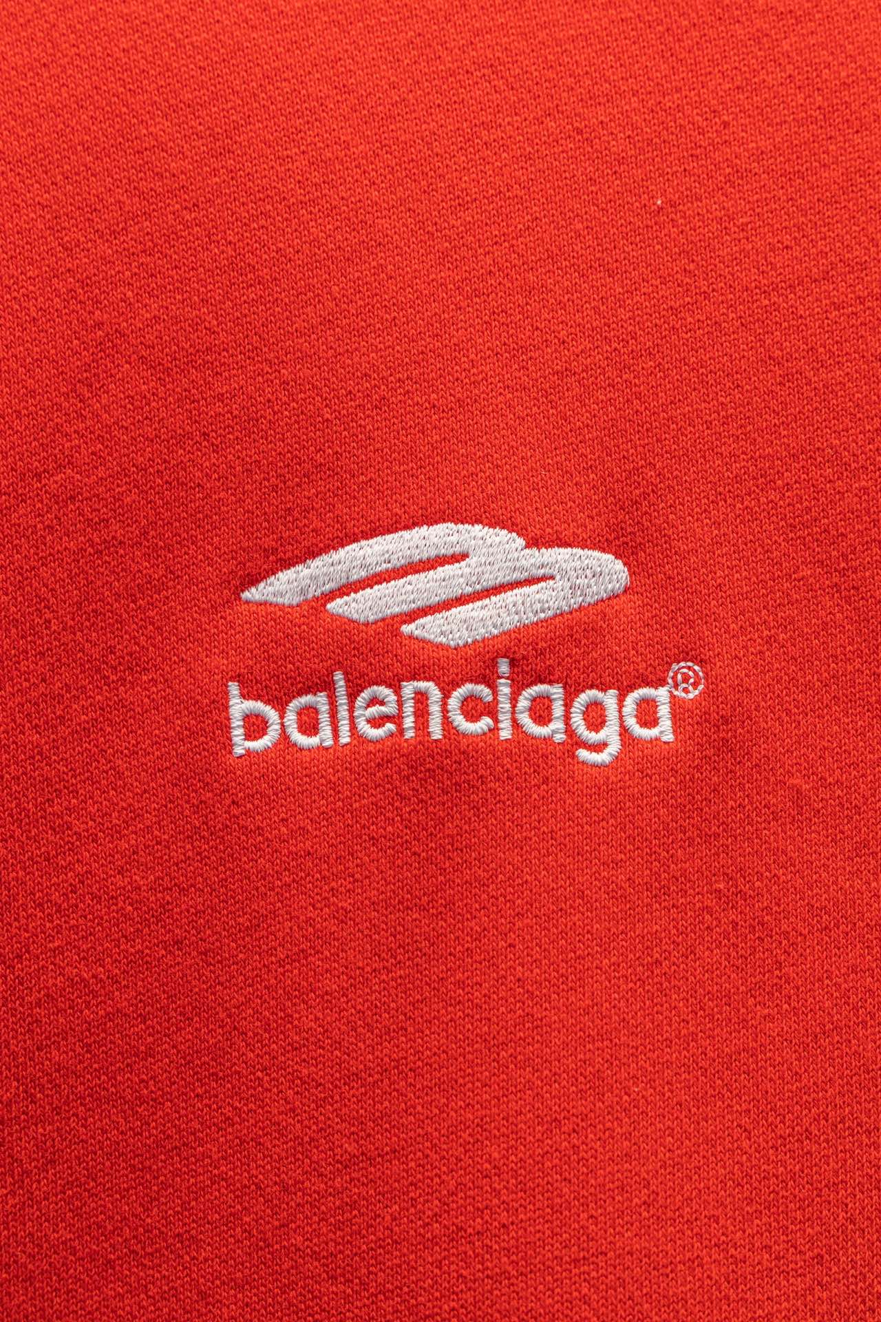 Red hoodie chest logo and zipper pull detail
