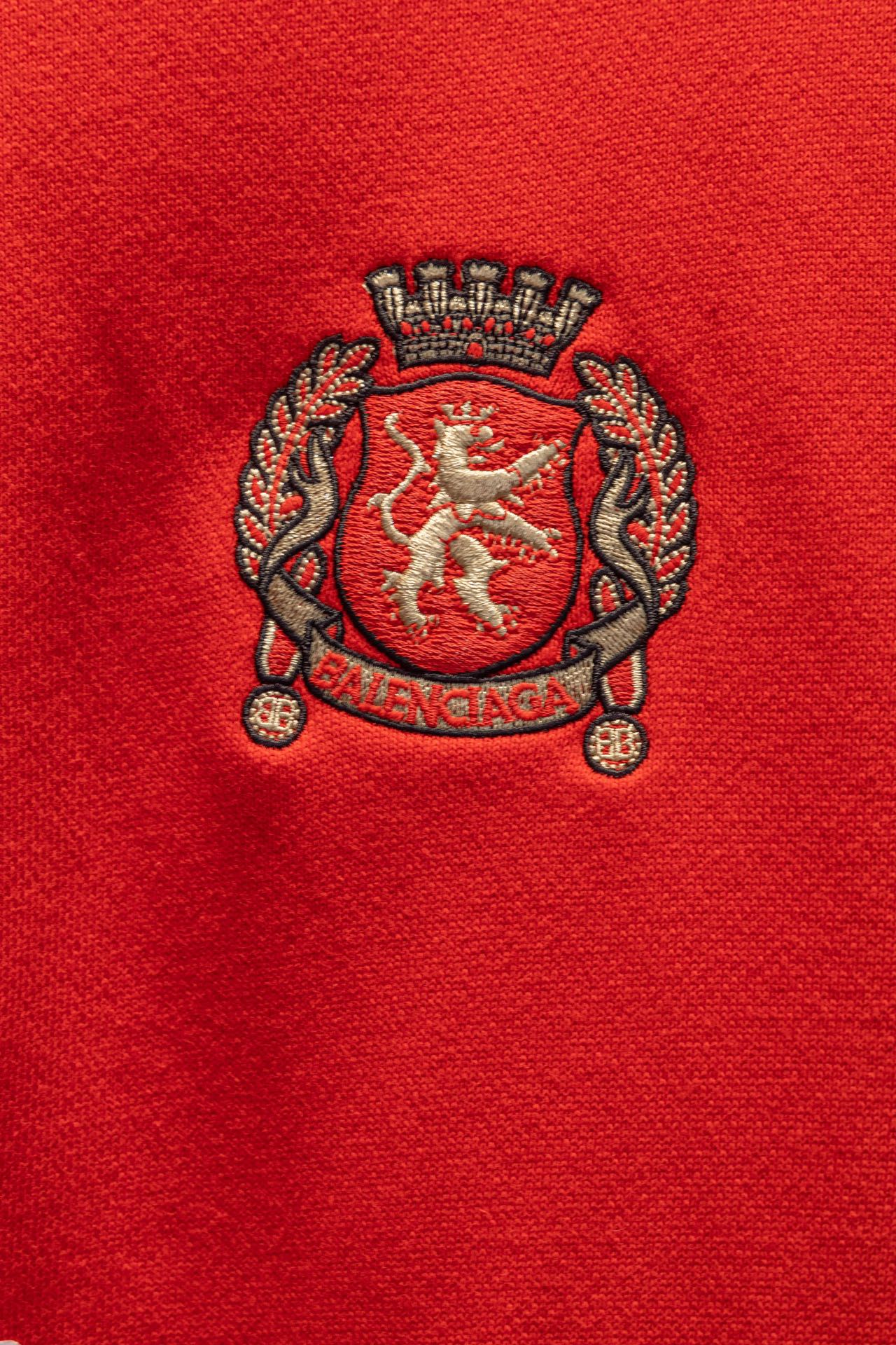 Red hoodie fabric with embroidered crest emblem