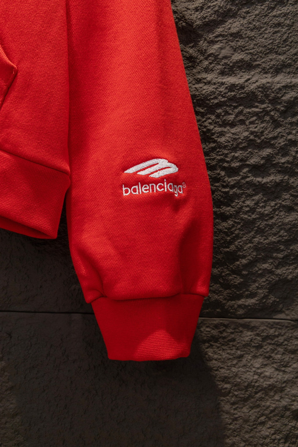 Red hoodie sleeve cuff with small logo on side