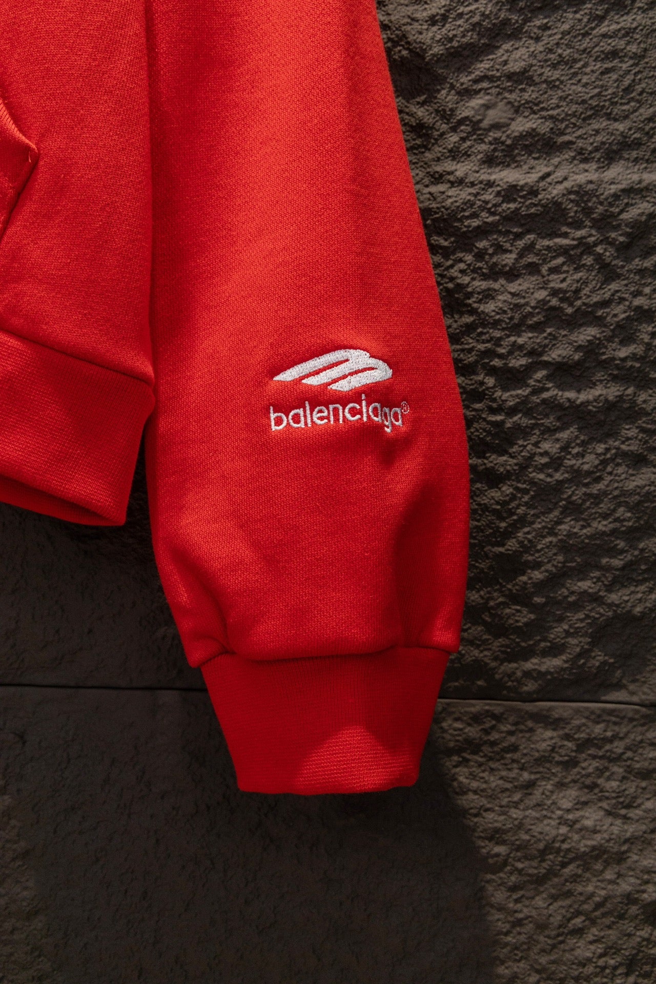 Red hoodie sleeve cuff with small logo on side