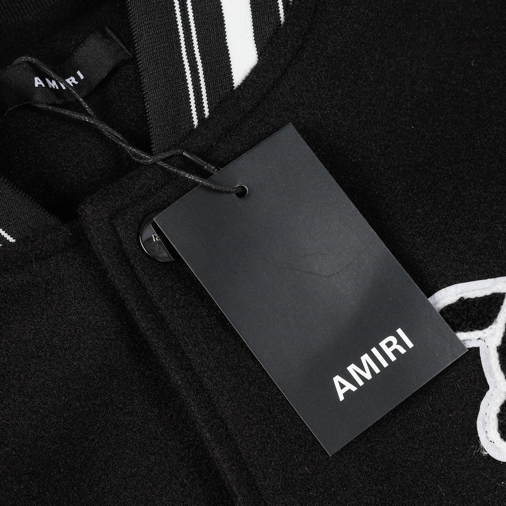 Black jacket close-up showing inner neck seam and AMIRI tag on fabric