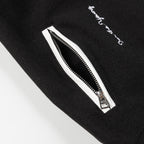 Black jacket with white zip detail and embroidered script near the zipper