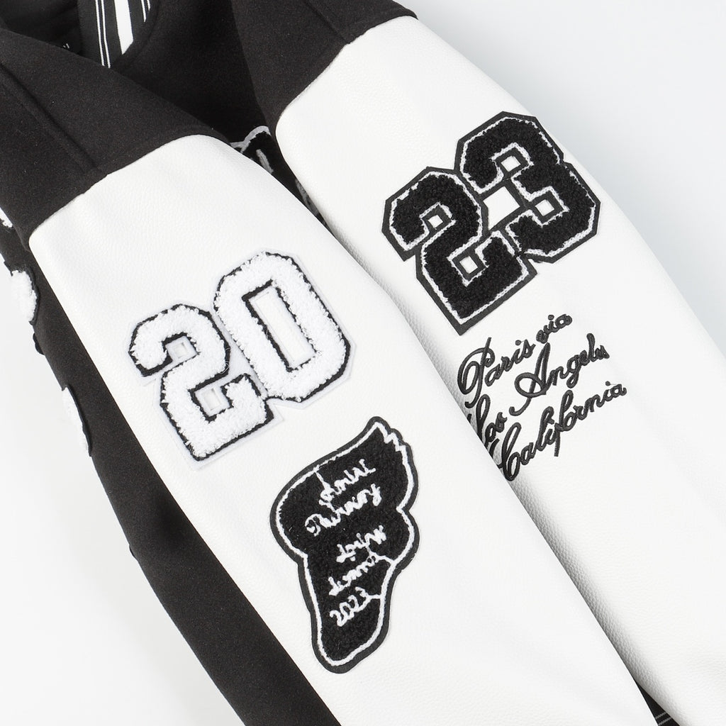 Black and white varsity jacket sleeves with embroidered patches and appliqué logos