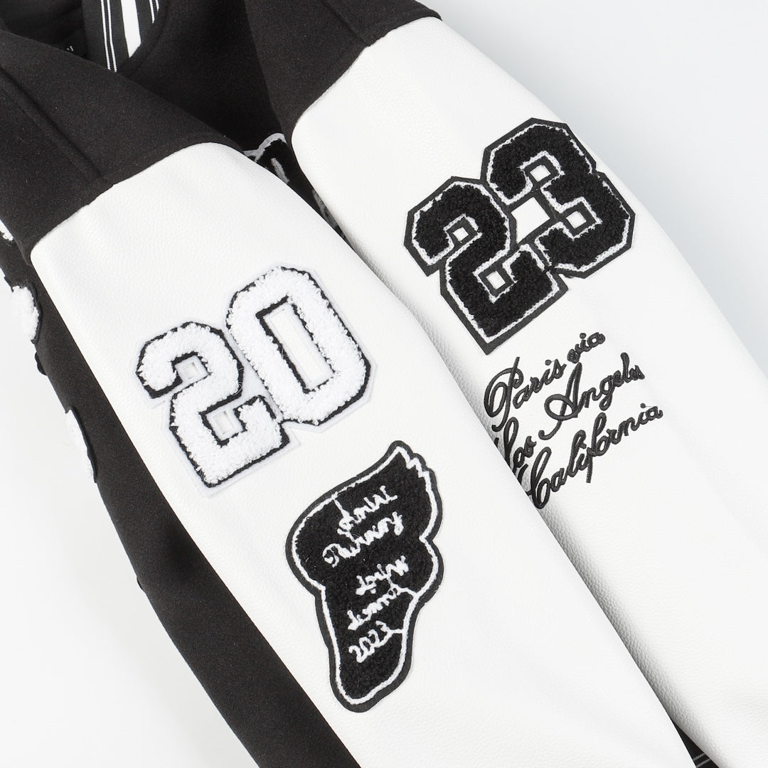 Black and white varsity jacket sleeves with embroidered patches and appliqué logos
