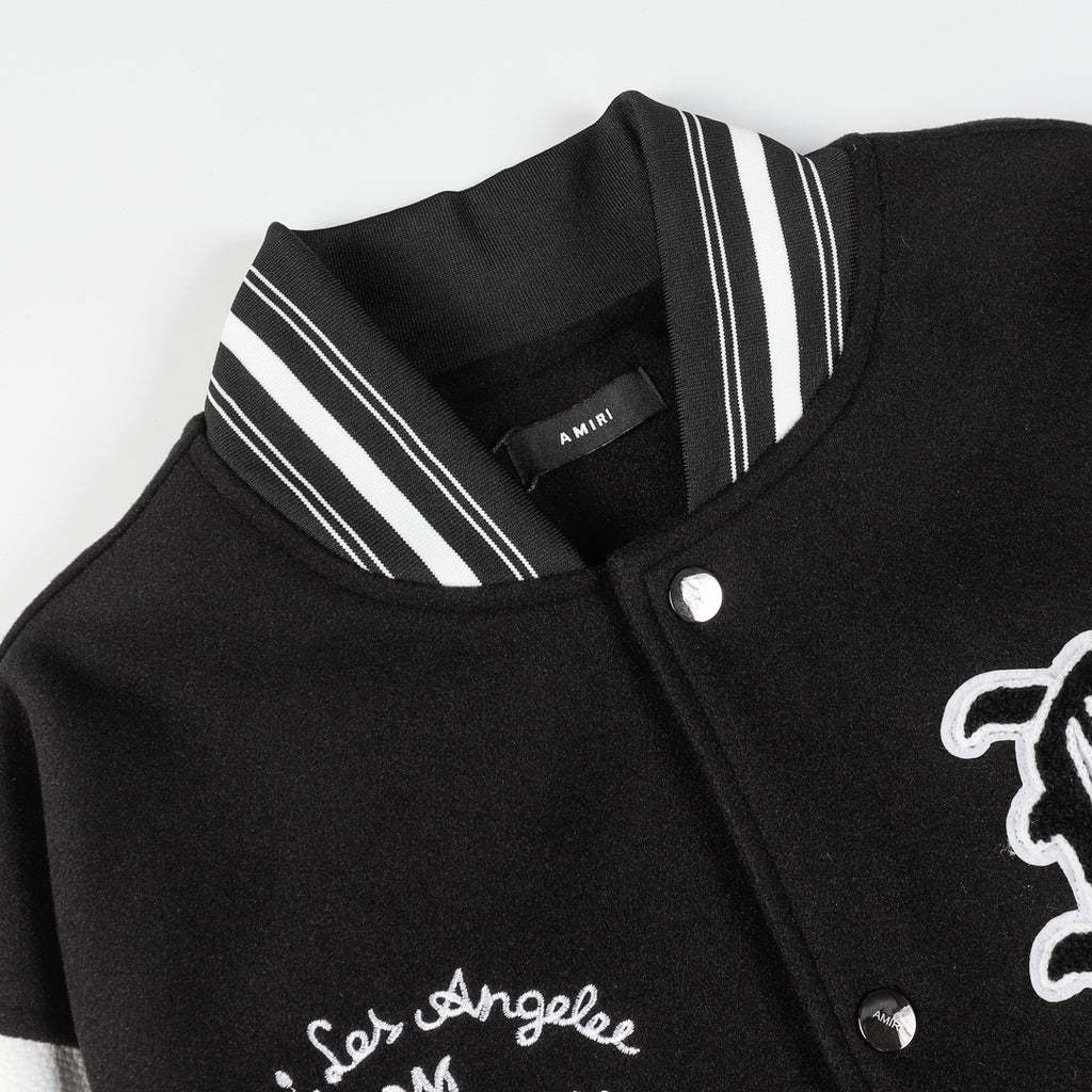 Black varsity jacket close-up with striped ribbed collar and snap button placket