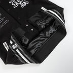 Black varsity jacket open front with inner lining and striped trim at cuffs