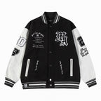 Black and white varsity jacket with snap buttons, ribbed collar, and striped cuffs